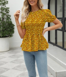 Detail view of mustard floral blouse with smocked waist and ruffled hem for summer