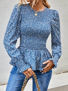 Detail of blue floral blouse with smocked cuffs and a peplum hem for a stylish look