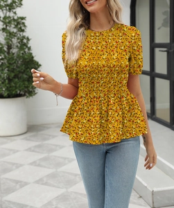 Detail of yellow floral smocked top with puffed sleeves and delicate frilled hem finish