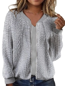Detail of cable-knit texture and zipper closure on a grey baseball style jacket