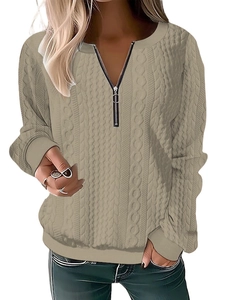 Detail of cable knit texture and zipper neckline on beige long sleeve sweater
