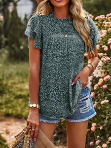 Close-up of ruffles on the collar and sleeves of this dark green polka dot chiffon shirt