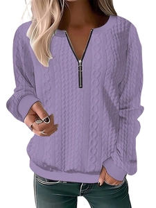 Detail of purple cable knit sweater showing zipper V-neck and rich braided texture