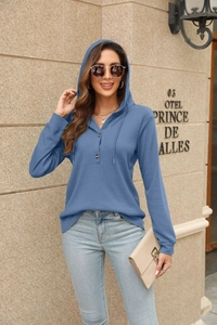 Detail of blue waffle knit hoodie featuring shoulder drop design and wooden buttons