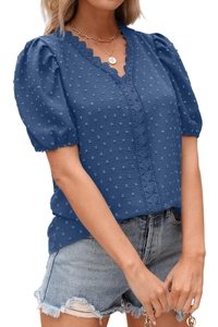 Dettaglio del tessuto blu navy Swiss Dot con pizzo delicato sullo scollo a V
