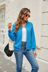 Detail of bright blue zip-up jacket with textured diamond pattern and stand collar