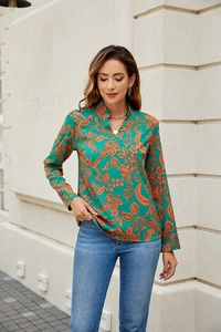 Detail of floral emerald green V-neck long sleeve blouse with vintage orange flower print