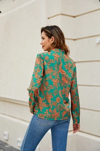 Detail view of green floral V-neck shirt back with silk texture and orange botanical print