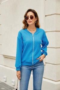 Detail of blue zip-up knit jacket with cable knit texture and stand collar