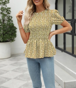Detail of smocked waist floral print summer blouse with ruffled hem and yellow pattern