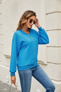 Detail of blue cable knit texture and smooth metal zipper on casual zip-up sweater jacket