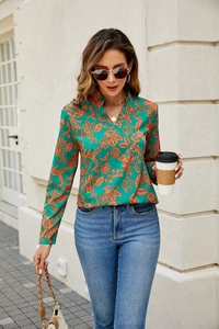 Detail of V-neck floral blouse with green orange prints and long sleeves on model