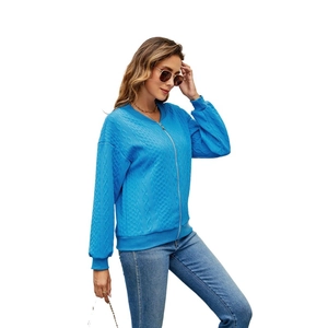 Close-up of blue waffle-knit texture and silver zipper detail on women's jacket