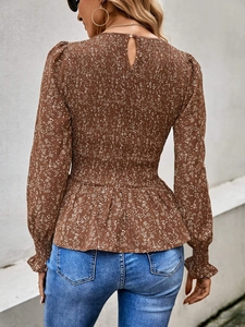 Detail view of the smocked waist design and back button on this floral long sleeve shirt