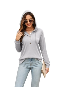 Detail of light grey waffle knit hoodie showing henley neck with brown buttons and texture