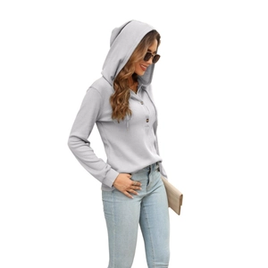 Close-up of light gray waffle knit texture and wooden buttons on women's hoodie