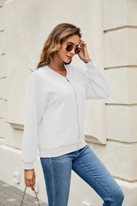 Close-up of white zip-up jacket featuring quilted knit texture and ribbed stand collar
