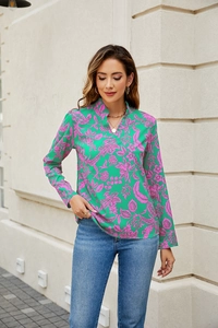Detail of vibrant green V-neck long sleeve blouse with pink floral prints on a female model