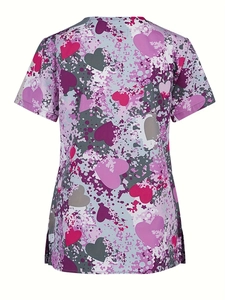 Detail view of the heart print pattern and side split on a purple short-sleeve nurse scrub top