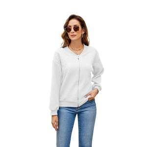 Close-up of a white zip-up knitted hoodie showing fine textured fabric and ribbed cuffs