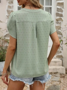 Détail du haut en mousseline vert avec col en V au dos et motif à pois suisses