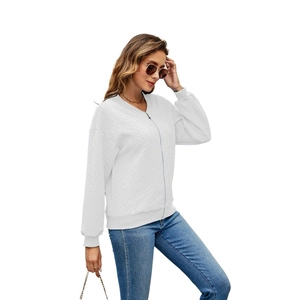 Detail of white long sleeve zip-up jacket featuring quilted diamond texture and ribbed cuffs