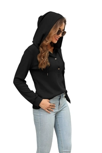 Detail of waffle knit fabric and wood-texture buttons on a black hooded long sleeve top