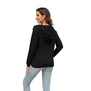 Detail of black waffle knit fabric on long sleeve hoodie with hood and textured surface