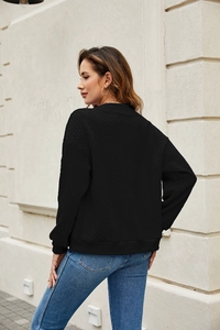 Detail of black jacquard knit sweatshirt with drop shoulder design and ribbed cuffs