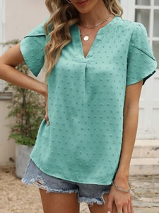 Détail du haut vert menthe à col en V avec texture à pois suisses et manches volantées