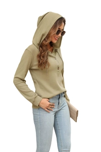 Close-up detail of green waffle knit texture and buttoned neckline on hooded long sleeve top