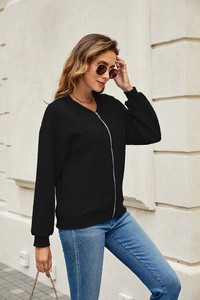 Detail of black waffle-knit zip-up jacket with ribbed cuffs and silver zipper