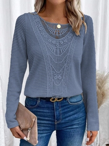 Dettaglio del tessuto a nido d'ape blu con elegante scollo in pizzo sulla maglia top