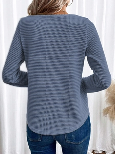 Vista posteriore dettagliata di un top blu in maglia a nido d'ape con bordo arrotondato