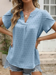Détail de la blouse bleu clair à col en V avec texture à pois suisses et tissu léger