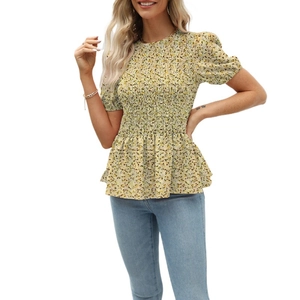 Detailed view of the yellow floral smocking fabric and ruffled peplum hemline on the blouse