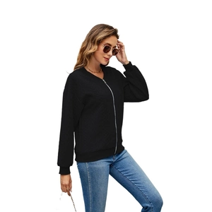 Detailed view of the black zip-up hoodie featuring fine vertical textured fabric and ribbed cuffs