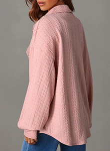 Dettaglio della camicia rosa chiaro a maniche lunghe con tessuto testurizzato e revers