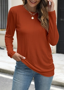 Detail view of brick red ribbed knit top with decorative side buttons and long sleeves
