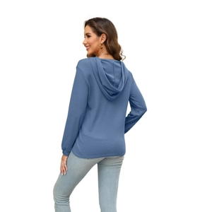 Detail view of the waffle knit fabric and drawstring hood on this blue long sleeve top