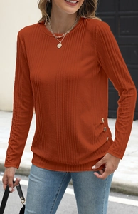 Detail of rust orange ribbed knit shirt with side button accents and crew neck