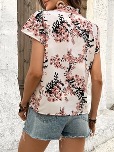 Rear view of floral short sleeve blouse featuring delicate ruffles and pink floral print
