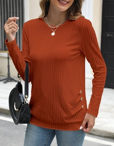 Detail of rust orange ribbed knit shirt with side wooden button accents and round neck