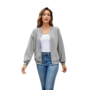 Detail of grey cable knit bomber jacket featuring zipper closure and ribbed cuffs