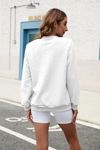 Detailed back view of white long-sleeve sweatshirt showing cable knit texture and ribbed hem