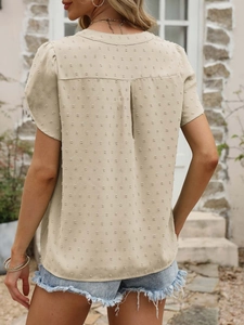 Détail de la blouse d'été abricot avec texture Swiss dot et pli plat au dos