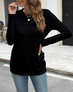 Detail of black ribbed knit long sleeve shirt featuring side gold button accents