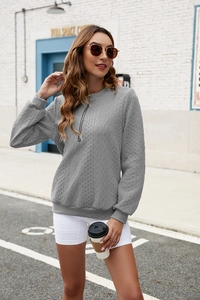 Close-up of gray cable knit texture and half-zip collar on long sleeve sweater