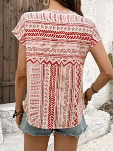 Back view of a red and white geometric patterned short sleeve top with bohemian motifs