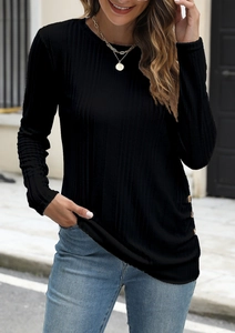 Detail of ribbed knit black long sleeve top featuring decorative gold buttons on side hem